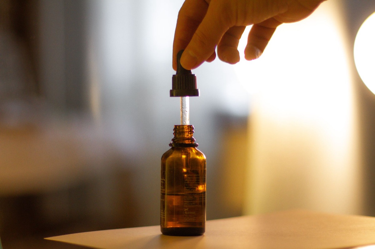 Un uomo misura l'olio da un contenitore